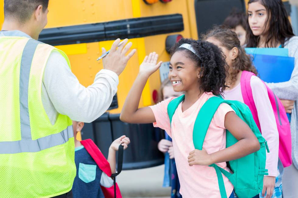 children getting off the bus and smiling